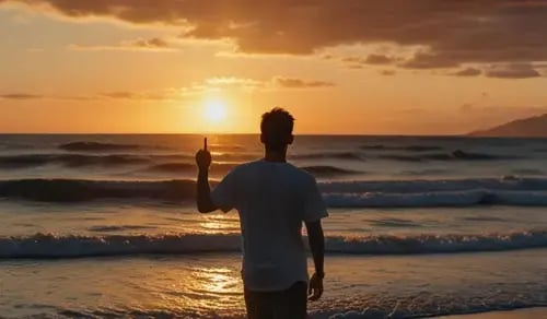 A young man strolls along a beach at sunset. Bigle Legal article on digital disconnection for in-house lawyers.