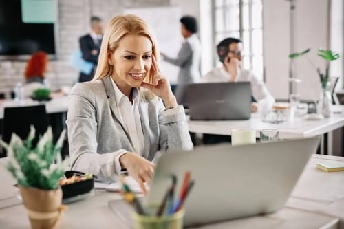 Smiling lawyer in front of her laptop benefiting from Bigle Legals CLM software.