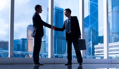Two executives shake hands. Bigle Legal article on compliance in the sales funnel.