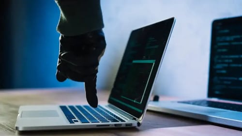 Hacker writes on a laptop. Bigle Legals CLM Security Article