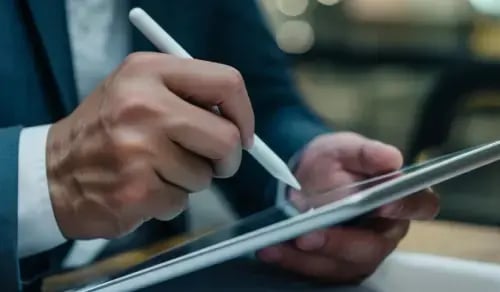 Hands of a lawyer signing a legal document on a tablet. Bigle article on CLM.