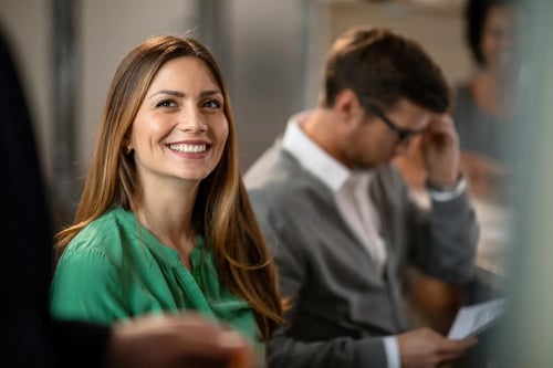 In-house lawyer smiles during a legal department meeting. Bigle Legal CLM article on legal tech.