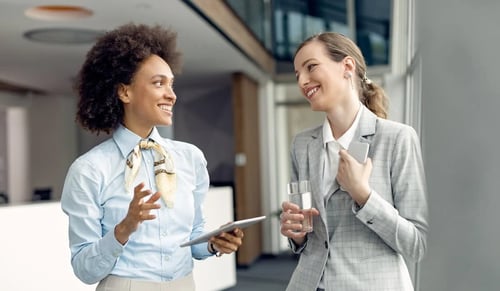 Jóvenes trabajadoras de recursos humanos charlan en la oficina. Artículo de Contract Lifecycle Management de Bigle Legal.