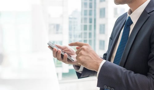 Lawyer works with his phone in a white office. Bigle Legal article on AI.