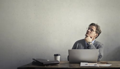 Man mulling over a new idea on his desk. Bigle Legal article on mistakes in the legal department.