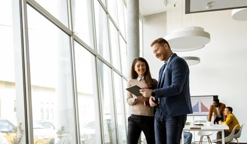 Young working couple walks with a tablet. Bigle Legal CLM article on ESG.