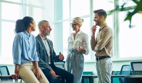 A group of lawyers chatting in a relaxed way in a bright office. Article by CLM company Bigle Legal.