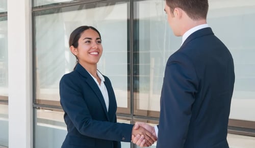 Two lawyers shake hands with smiling faces