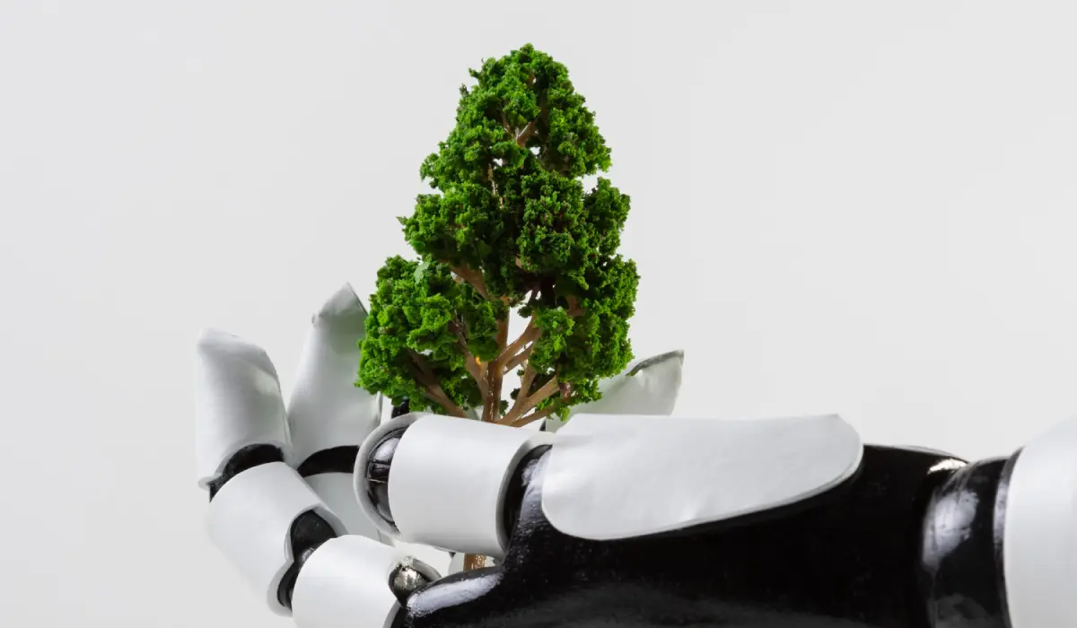 Mano robótica blanca y negra sostiene un árbol con la palma. Artículo de Bigle Legal CLM sobre una IA responsable y el ESG.