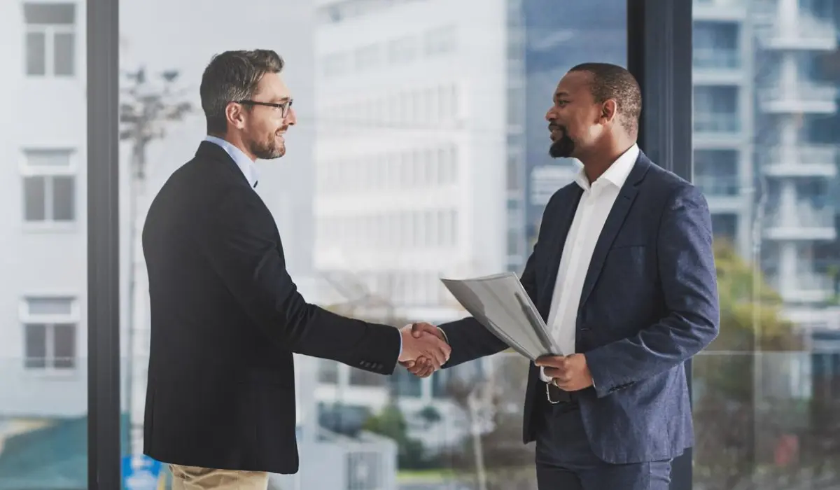 Suit-wearing lawyer shakes hands with legal tech vendor. Article by Bigle Legal CLM.